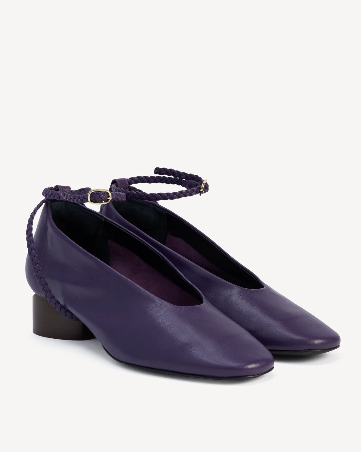 Angled pair of leather pumps with braided ankle straps and block heels. The Alma Anklet Pump Sapphire. Sizes 5–12.