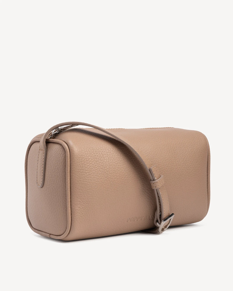 Angled view of cylindrical barrel bag with top zip and strap. The Annex Bag Biscotti.