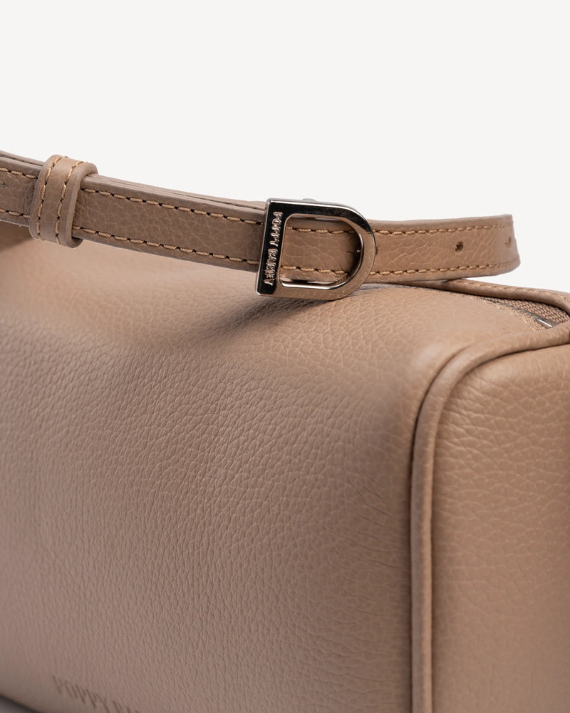 Close-up of gold-tone buckle hardware on bag strap. The Annex Bag Biscotti.