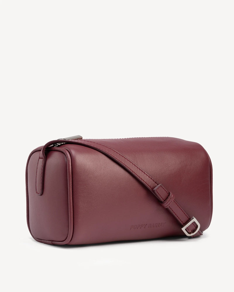Angled view of cylindrical barrel bag with top zip and strap. The Annex Bag Compote.