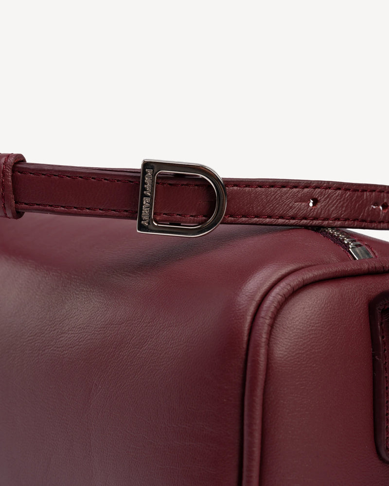 Close-up of gold-tone buckle hardware on bag strap. The Annex Bag Compote.