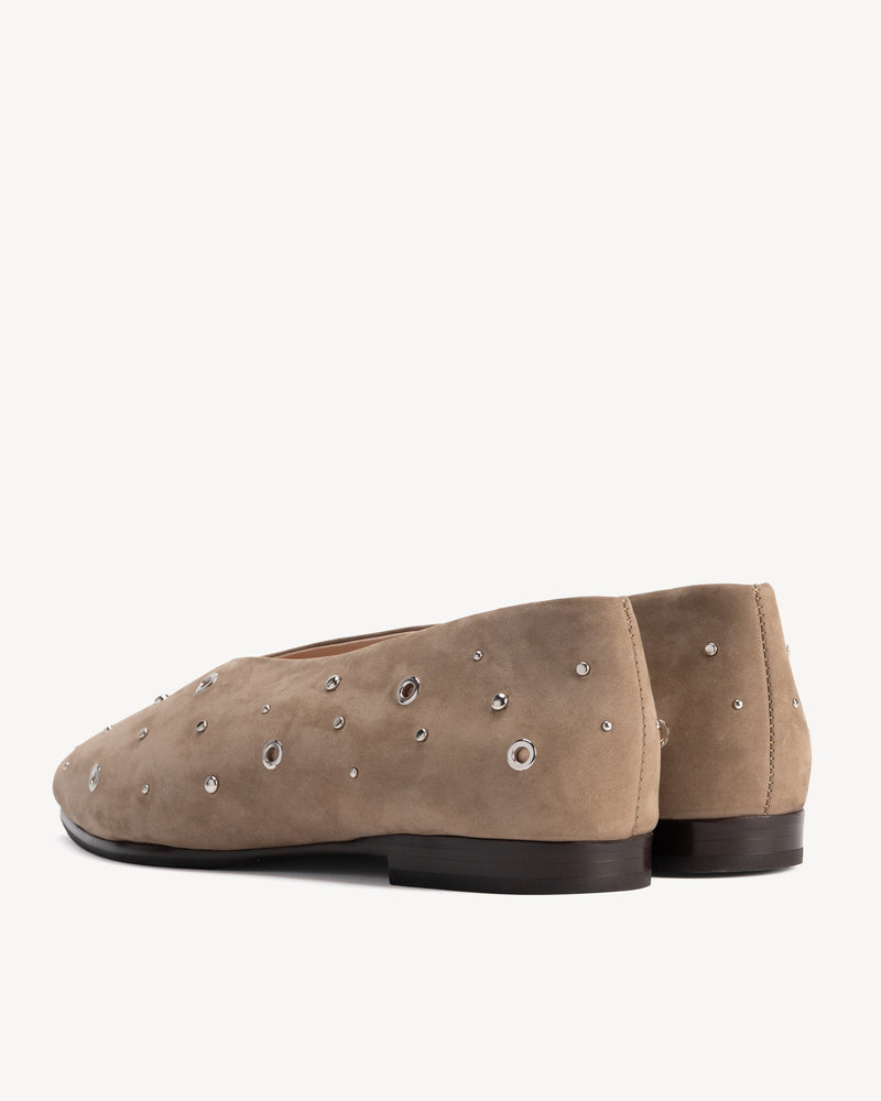 Flat lay of The Atelier Flat Clay Studded in Neutral nubuck. Sizes 5–12, wide available