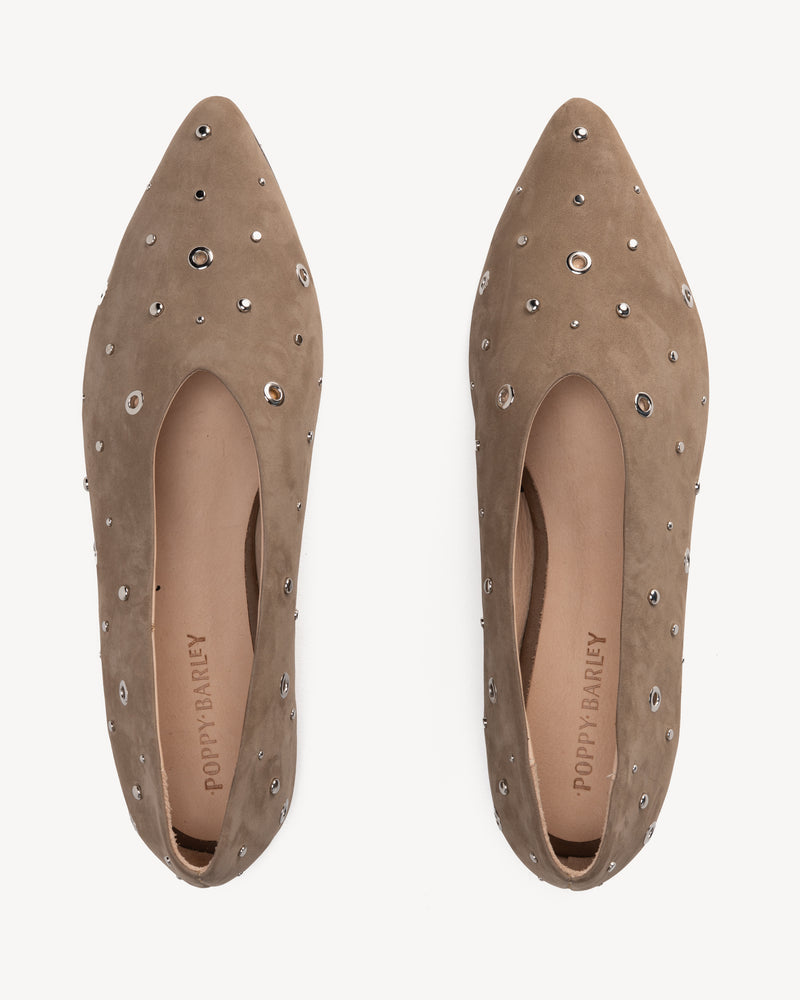 Flat lay of The Atelier Flat Clay Studded in Neutral nubuck. Sizes 5–12, wide available