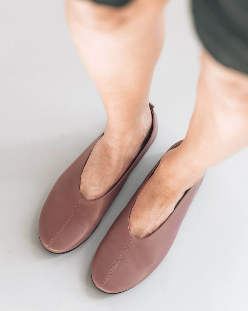 Leather ballet flats with round toe, overhead view with bare legs. The Contemporary Ballet Flat Ceramic. Sizes 5–12.