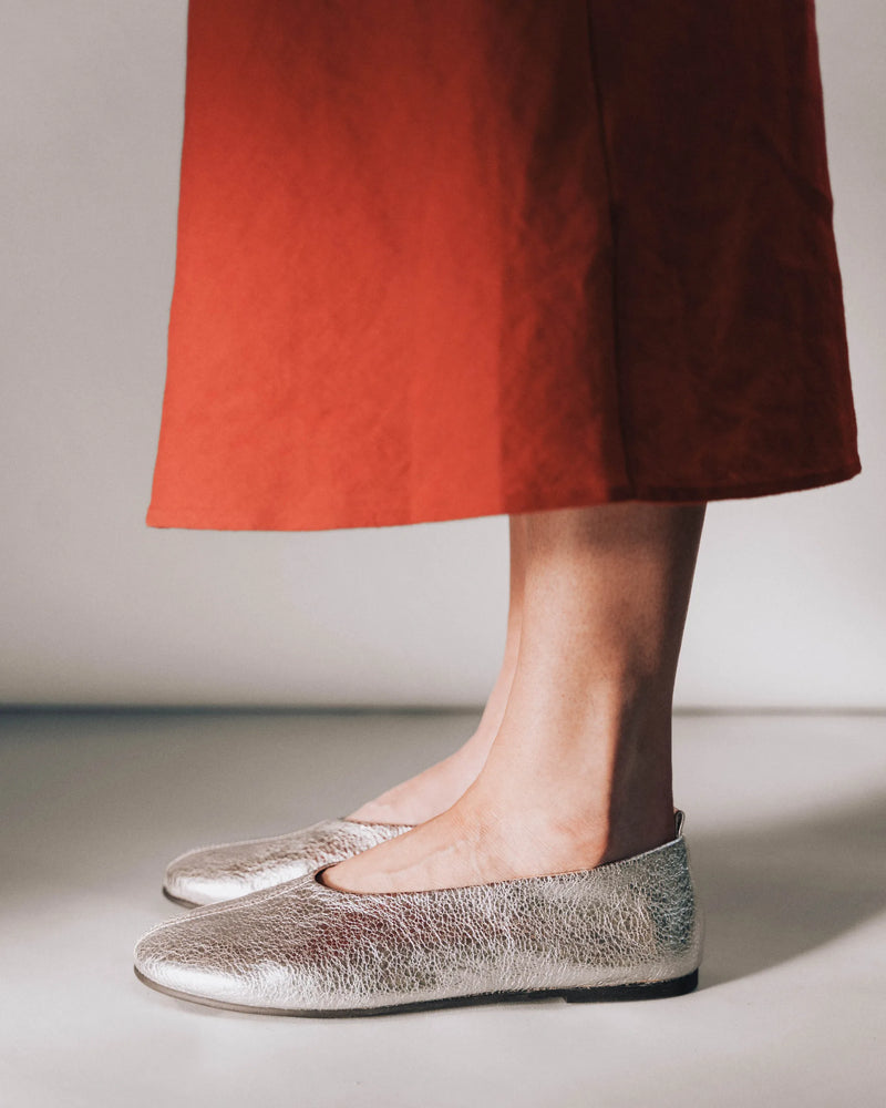 Metallic crinkle leather ballet flats, side view, terracotta dress. The Contemporary Ballet Flat Silver. Sizes 5–12.