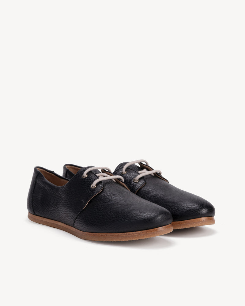 Angled view of The Eyelet Oxford 2.0 Black Pebble in pebbled leather. Sizes 5–12, wide available