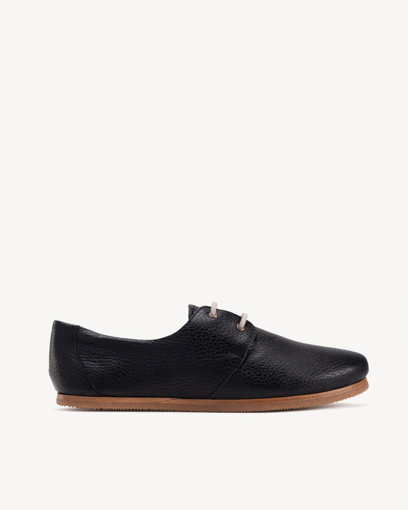 Side view of The Eyelet Oxford 2.0 Black Pebble in pebbled leather. Sizes 5–12, wide available