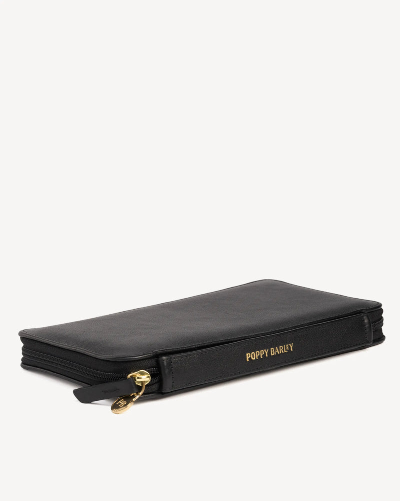Side view of the zip-around passport holder with embossed logo. The Flying Solo Passport Holder & Slim Luggage Tag Set Black.