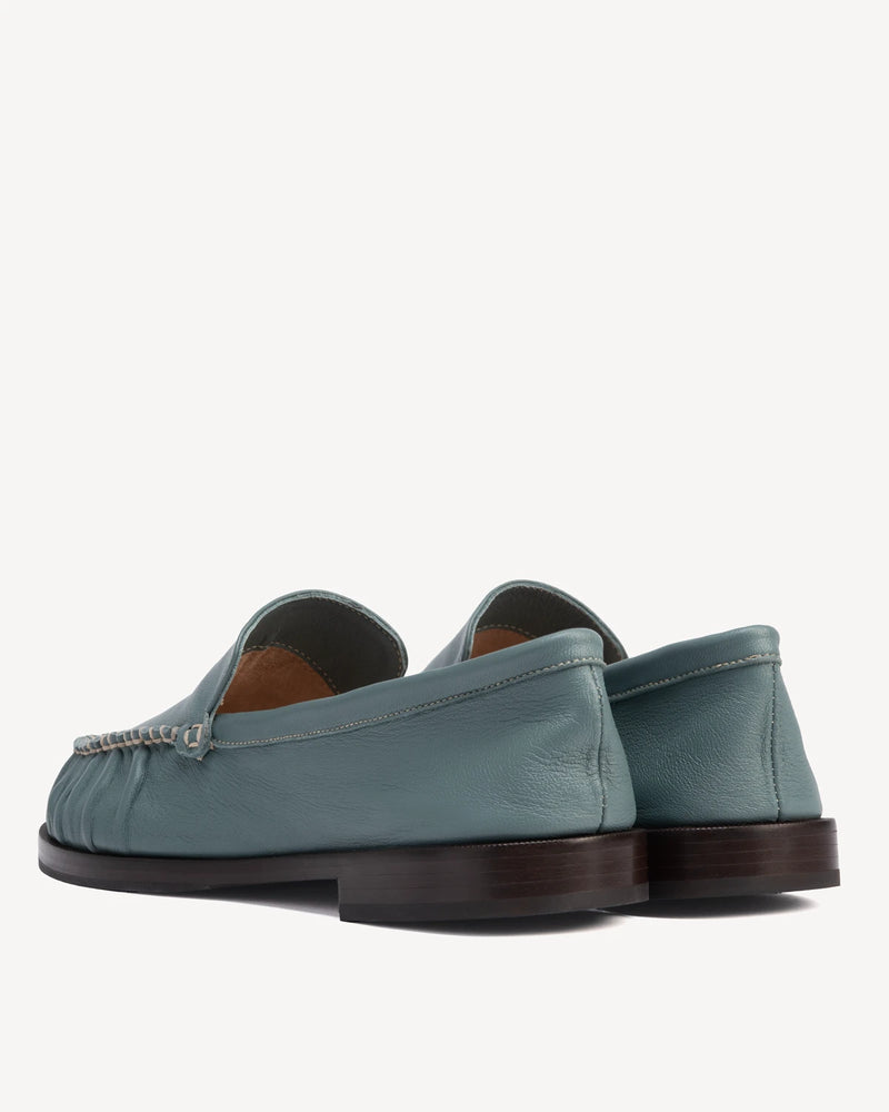 Back view of slip-on loafers showing heel and chain trim. The Laid Back Loafer Storm. Sizes 5–12, wide available.