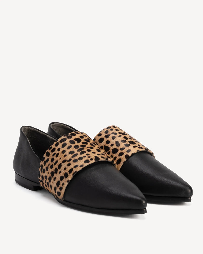 Angled view of flats with calf hair band. The Luxe Fit Flat Black and Cheetah Calf Hair. Sizes 5–12, wide available.