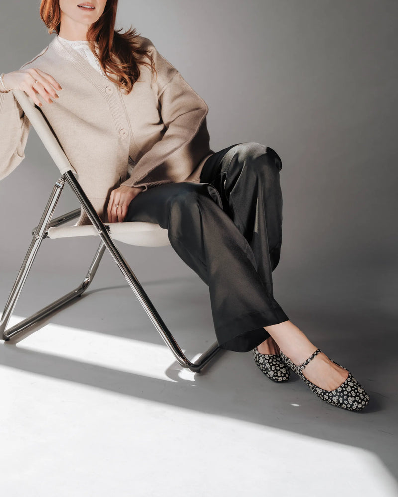 On-foot seated with cropped black trousers, strap fastened over the arch. The Studio Mary Jane Moonflower. Sizes 5–12.