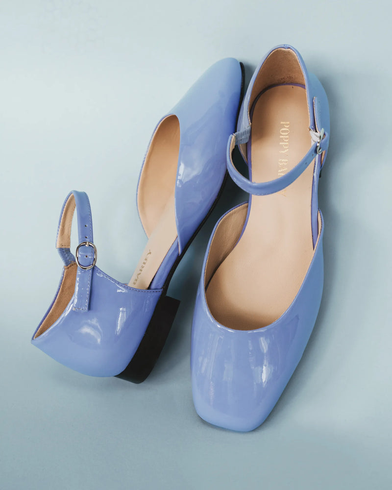 Angled pair view showing the branded suede insoles. The Gallery Mary Jane Cornflower Patent. Sizes 5–12.