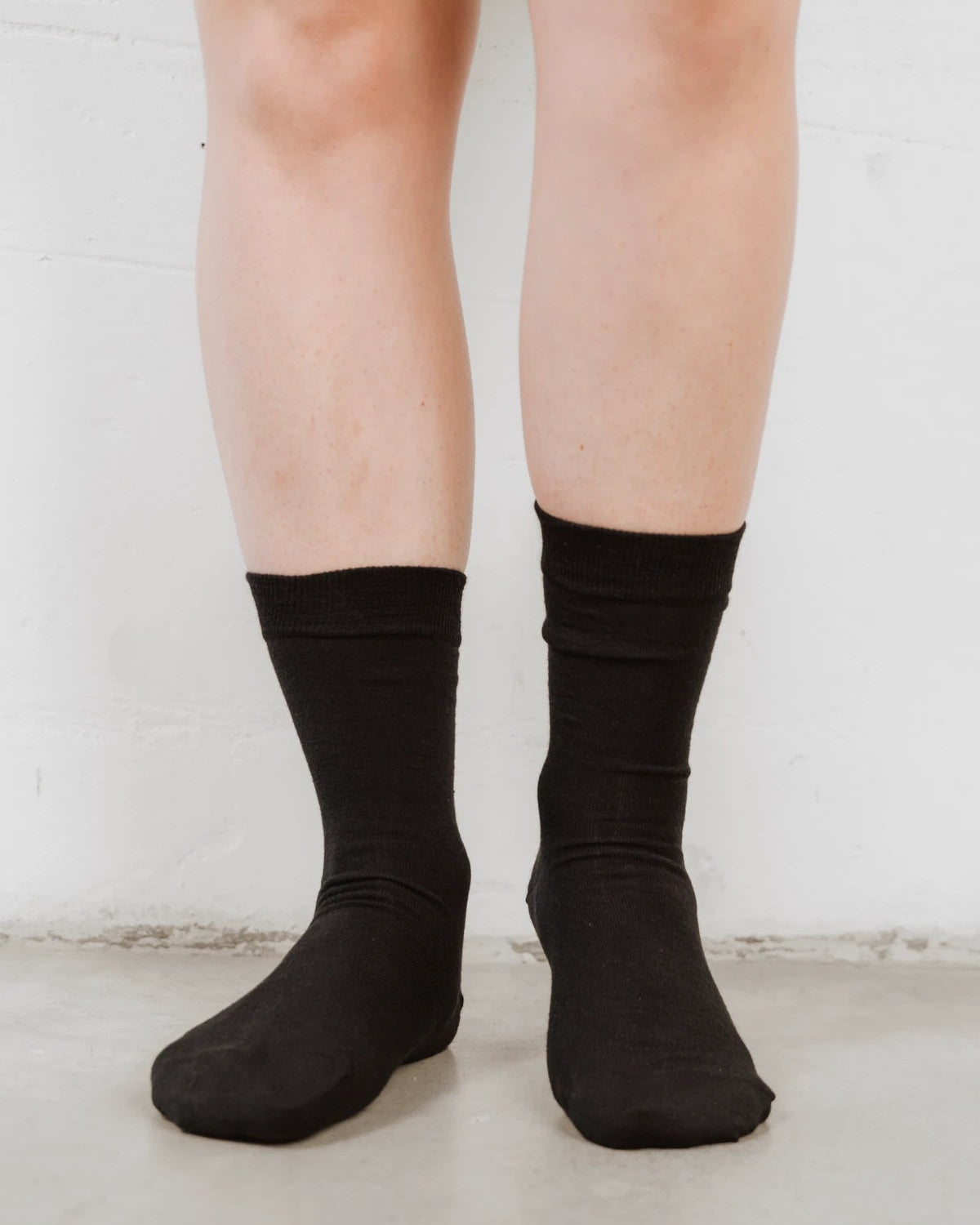 Straight-on view of crew socks reaching mid-calf, fine wool rib knit. The Dressy Crew Sock Black 3-Pack.