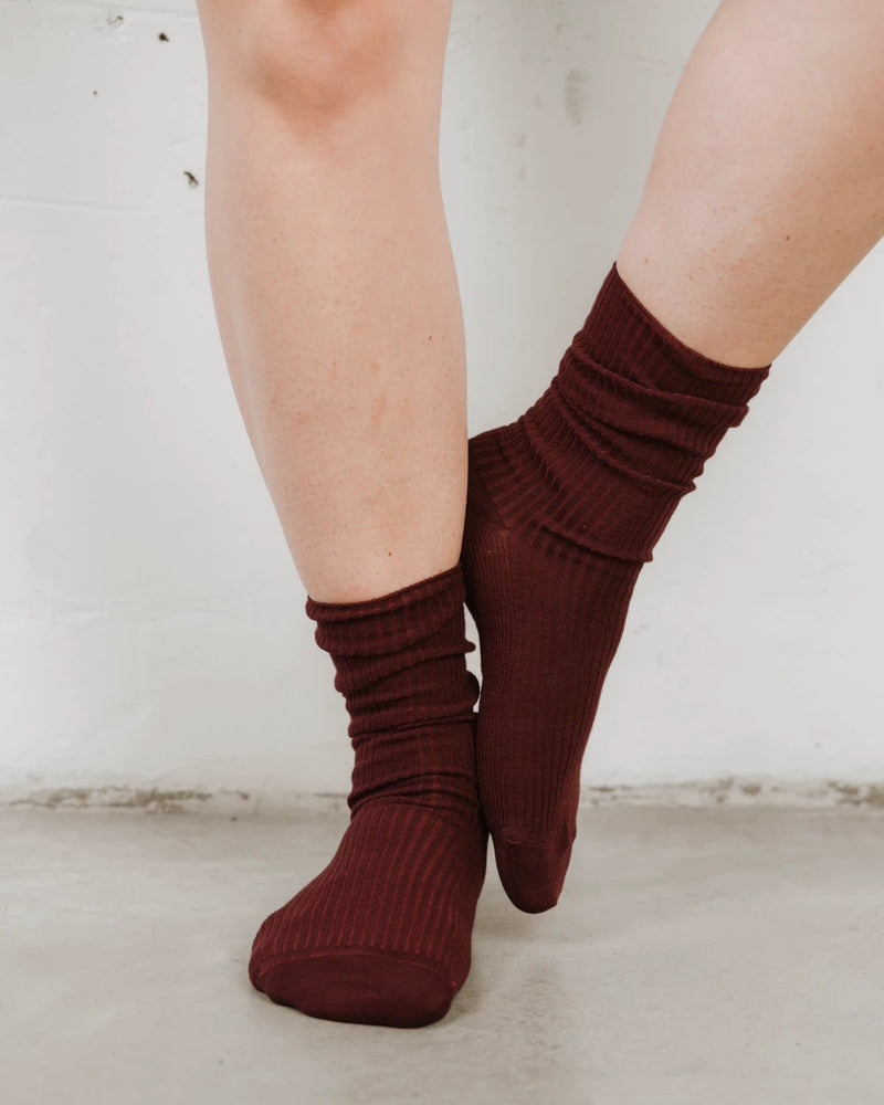 Front view on bare legs, ribbed knit with a slouched cuff. The Ribbed Crew Sock Sangria.