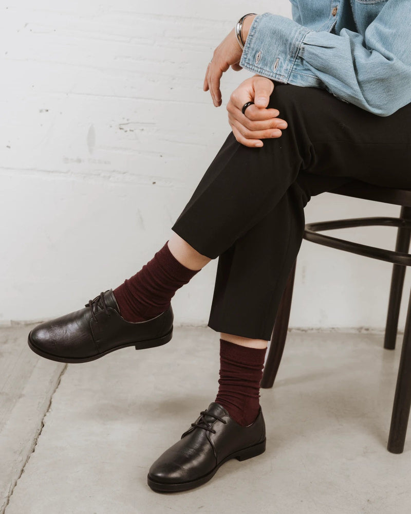 On-foot with black lace-up shoes, socks slouched at the ankle. The Dressy Crew Sock Port.