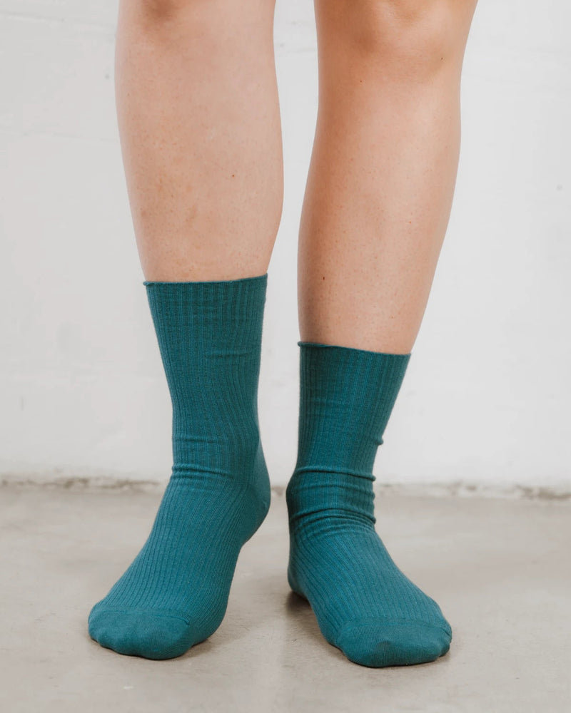 Front view of feet in ribbed knit crew socks with a folded cuff. The Ribbed Crew Sock Peacock.