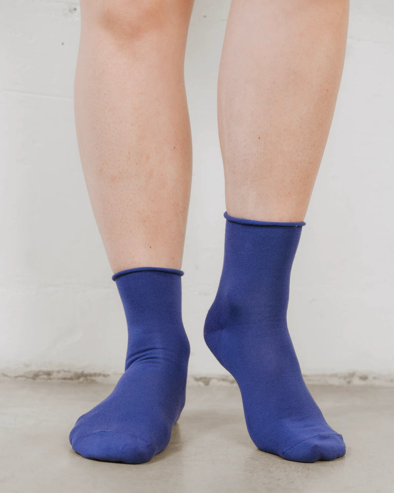 Front view on bare legs, smooth cotton knit with a rolled cuff. The Daily Mid Crew Sock Atlantic.