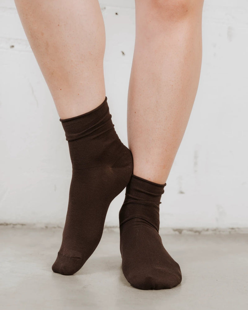Front view on bare legs, soft cotton-rich knit with a rolled cuff. The Daily Mid Crew Sock Ganache.