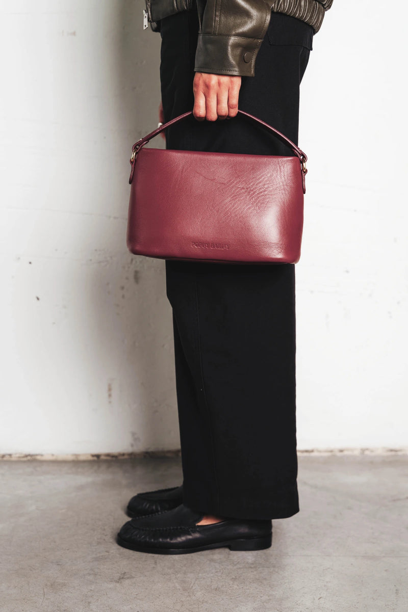 Bag held by its top handle. The Via Monte Bag Compote.