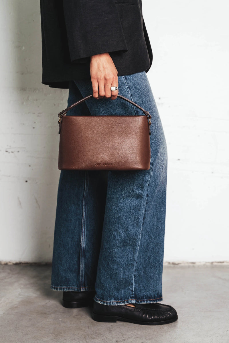 Bag held by its top handle. The Via Monte Bag French Press.