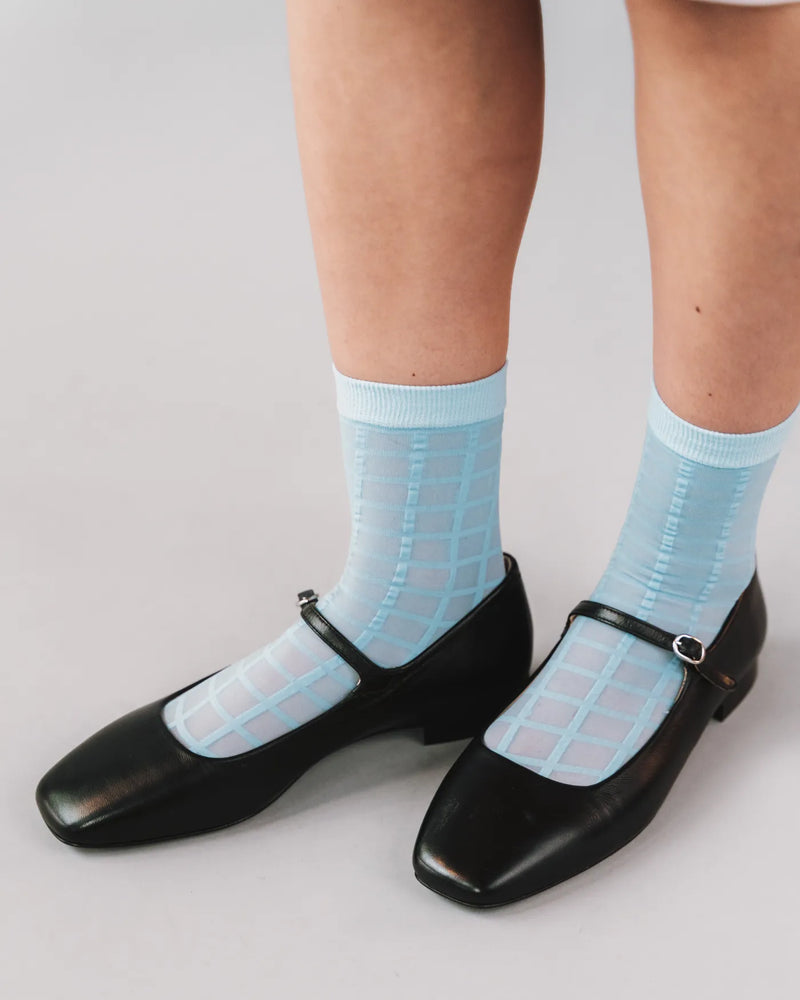 Checkered sheer socks styled with black leather Mary Jane heels. Rachel Checkered Sheer Socks in Sky Blue.