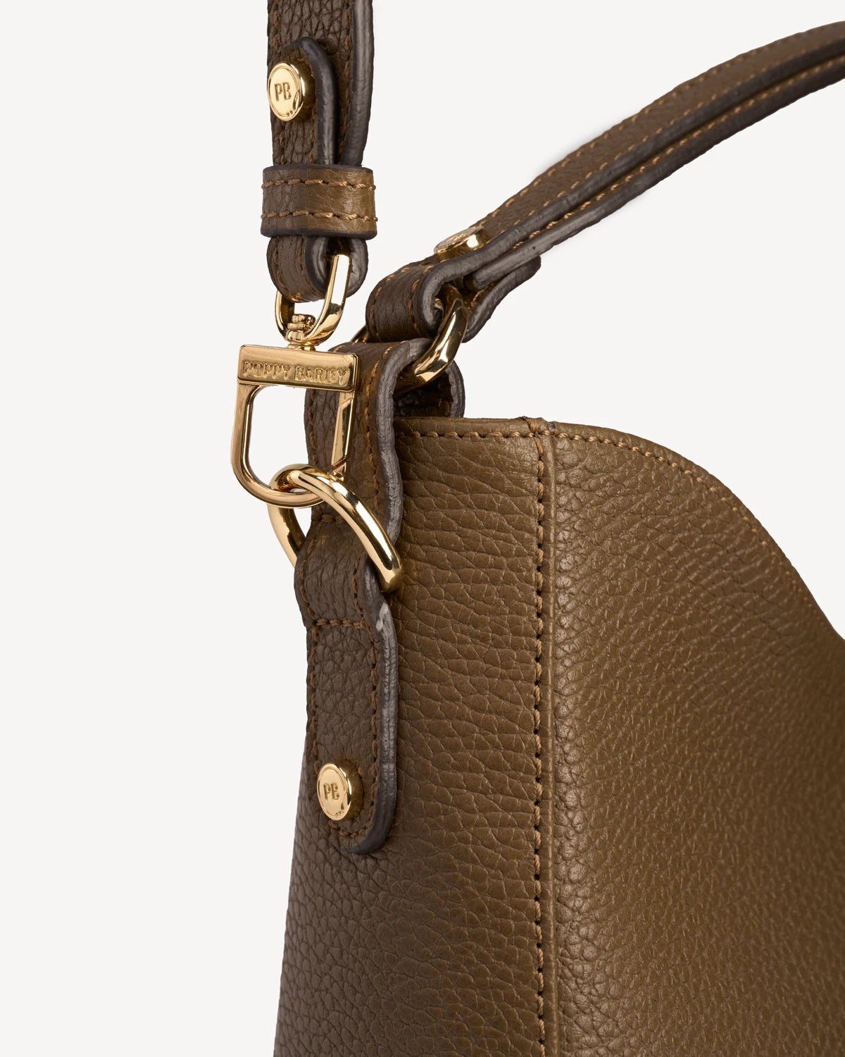 Close-up of the strap buckle and pebbled leather on the hobo bag. The Sixteenth Tote Tapenade.