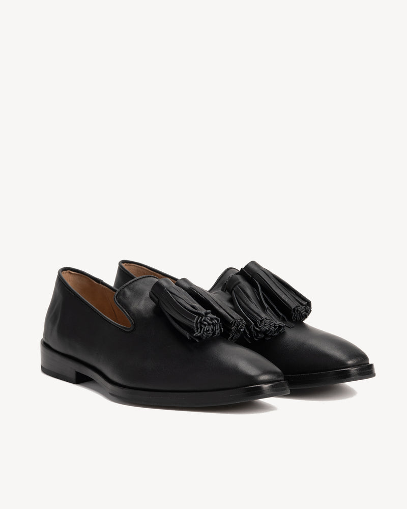 Angled view of The Tassel Daily Loafer Black in smooth leather. Sizes 5–12, wide available