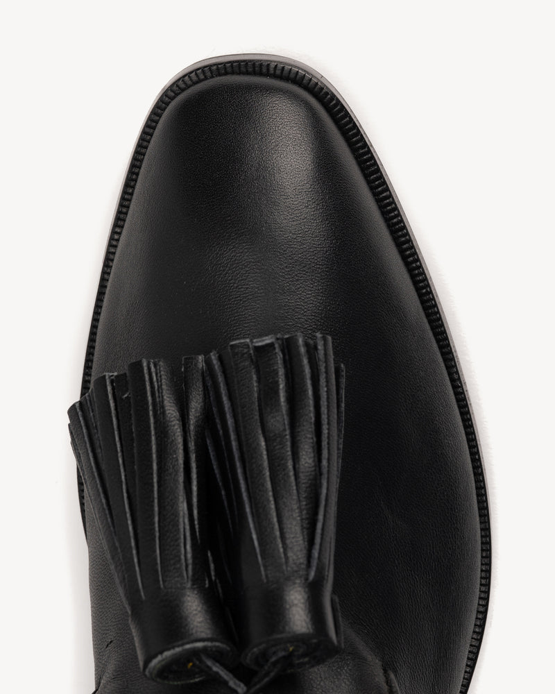 Close-up detail of The Tassel Daily Loafer Black in smooth leather. Sizes 5–12, wide available