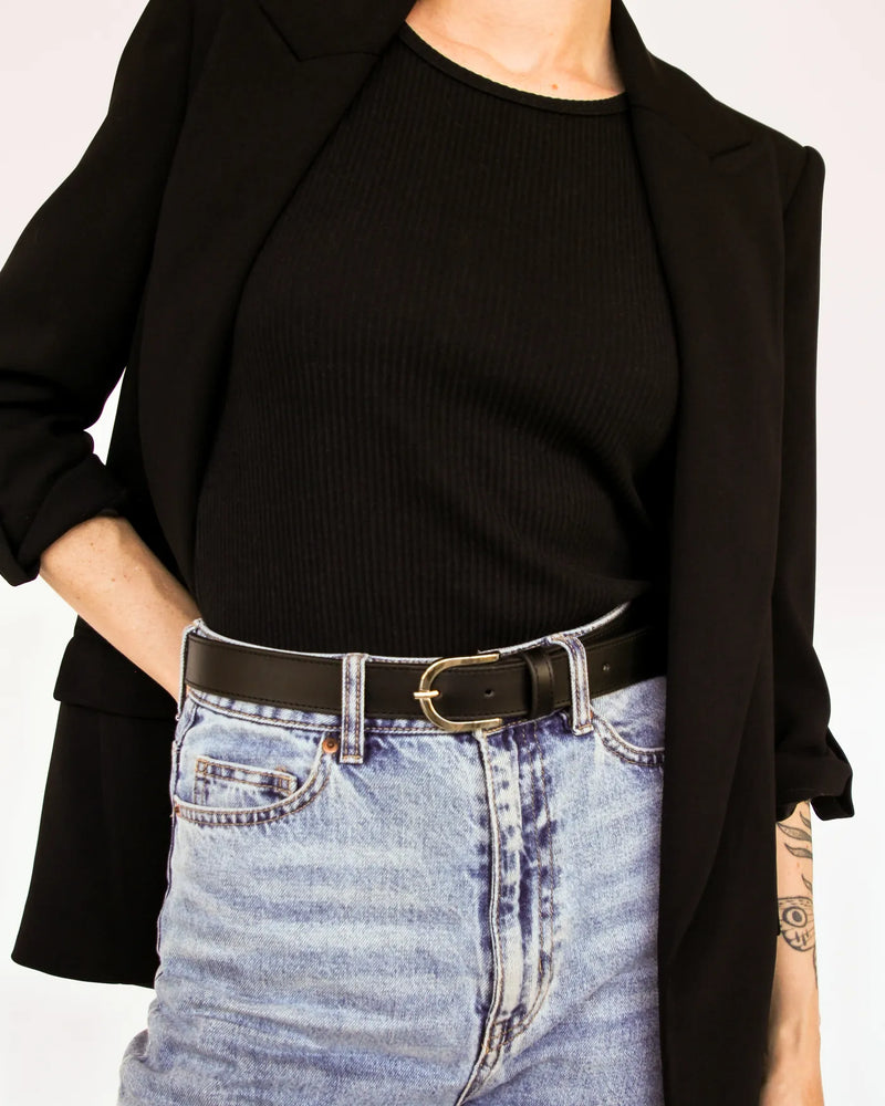 Black leather belt with silver buckle on woman styled with jeans and black blazer. The Accent Belt Silver Black.