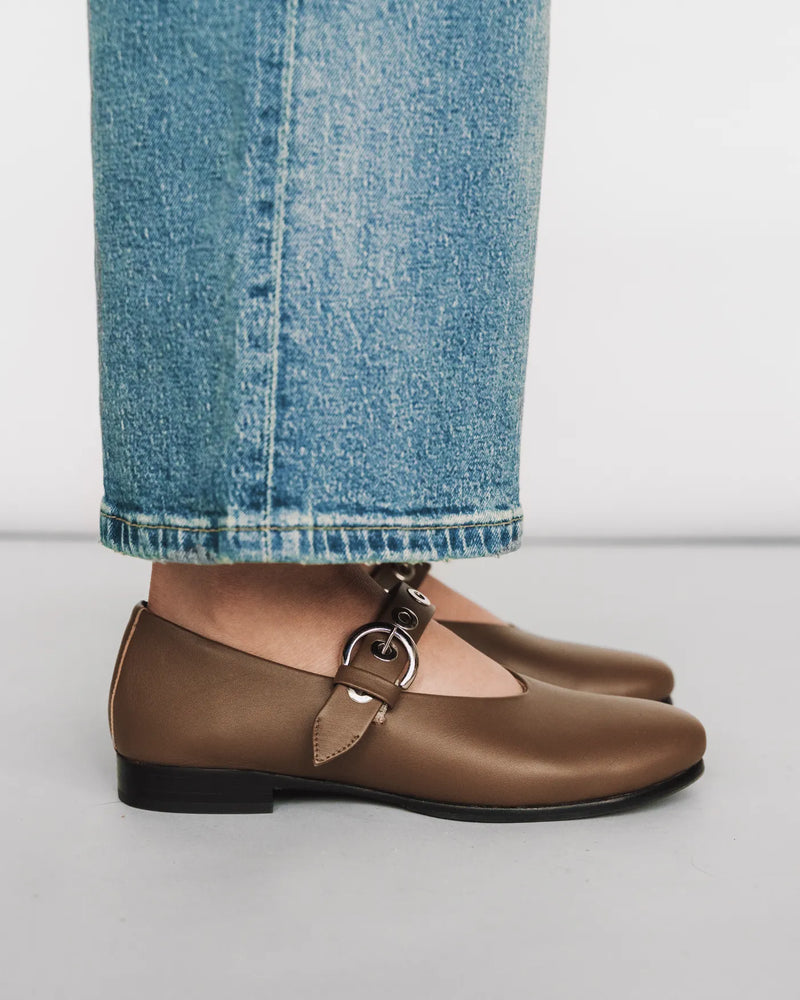 Leather Mary Jane with eyelet strap, worn with jeans. The BLVD Mary Jane Tapenade. Sizes 5–12, available in wide.