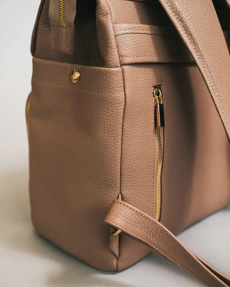 Close-up of the side zipper pocket and gold stud detail on a pebbled leather backpack. The Beyond Backpack Biscotti.