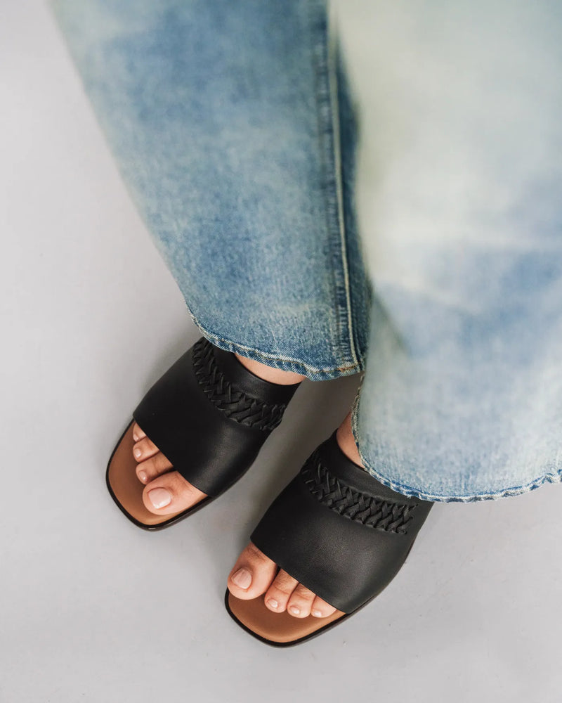 Leather heeled slides with woven detail, overhead view with light jeans. The Bohème Heeled Sandal Black. Sizes 5–12.