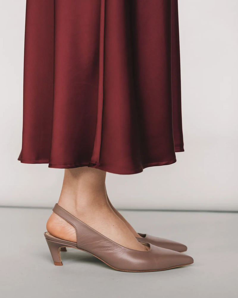 Ceramic leather slingback kitten heels, side profile with burgundy midi skirt. The Claire Slingback Ceramic. Sizes 5–12.