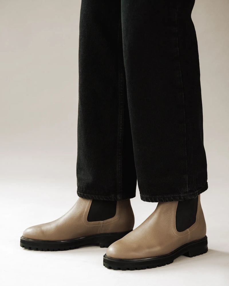 Woman wearing leather Chelsea boots with wide-leg black trousers. The Every Way Chelsea Boot Truffle. Sizes 5–12.
