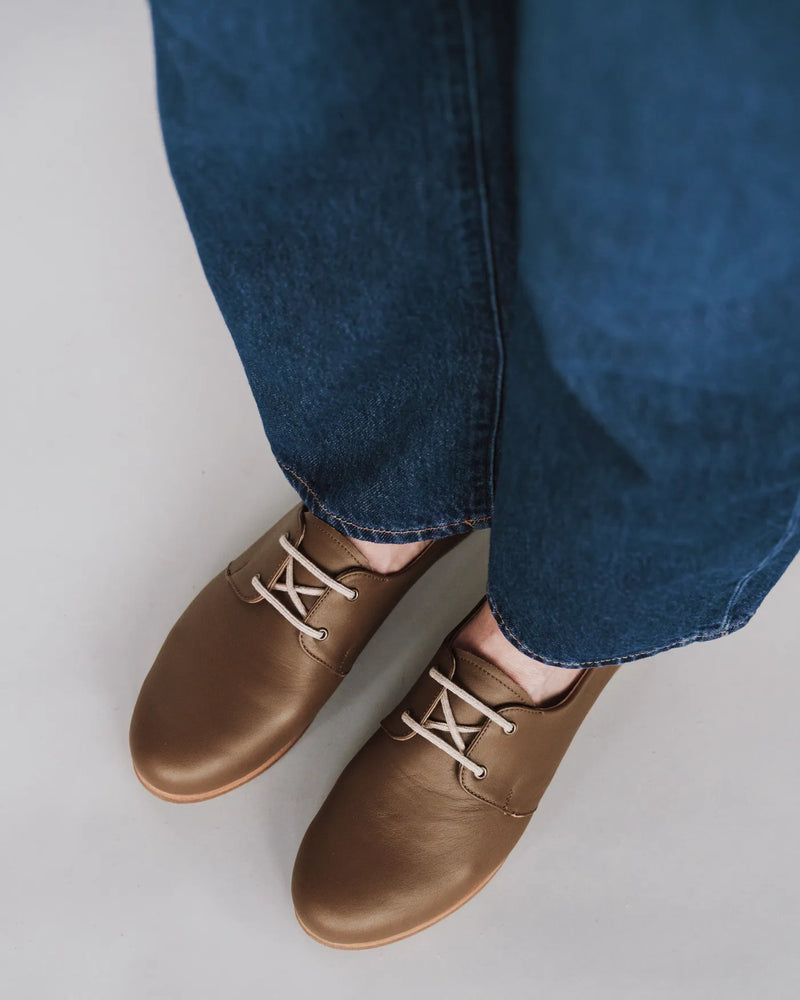 Leather oxford shoes worn with dark blue wide jeans. The Eyelet Oxford 2.0 Tapenade. Sizes 5–12, available in wide.