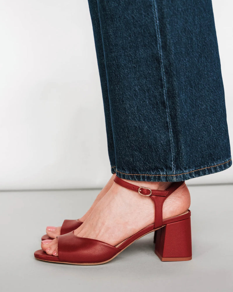 Leather block-heeled sandals with ankle strap, side view with dark jeans. The Mila Heeled Sandal Rioja. Sizes 5–12.