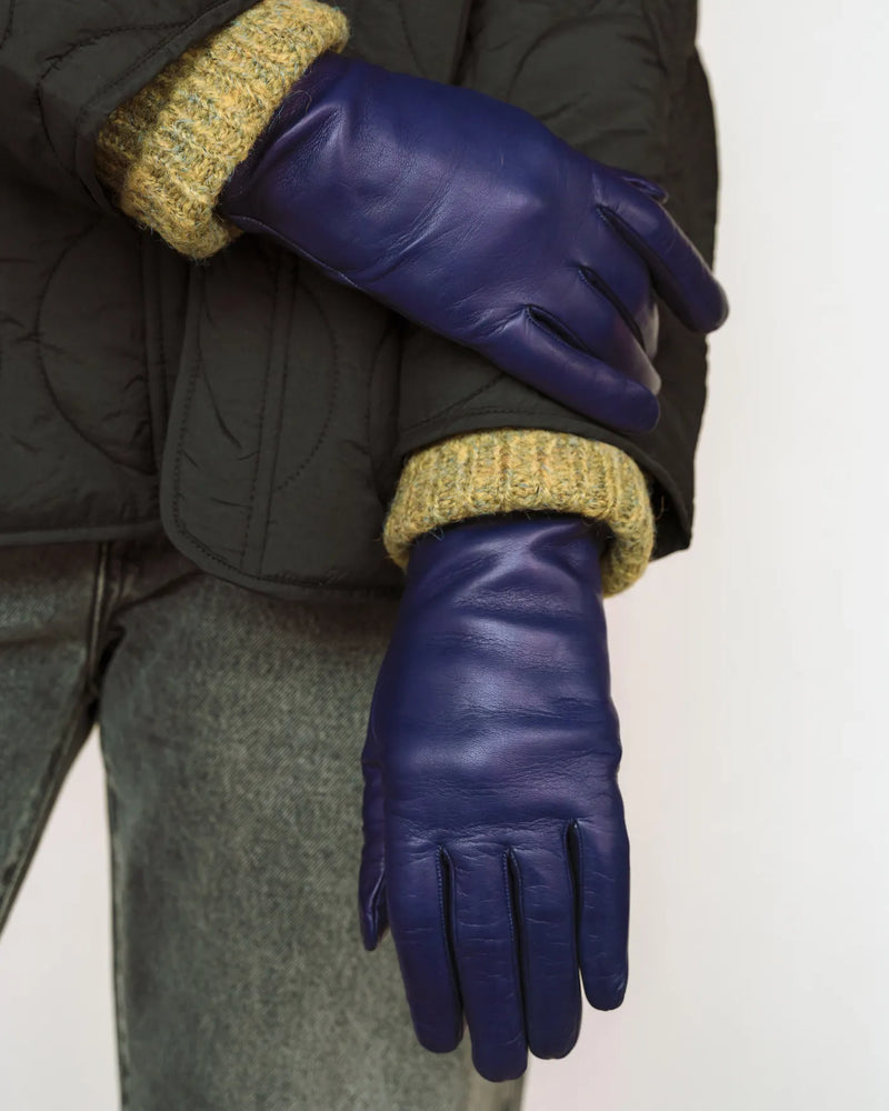 Woman nappa leather gloves, dark quilted jacket, mustard knit cuffs. The Sleek Leather Glove Royal Blue.