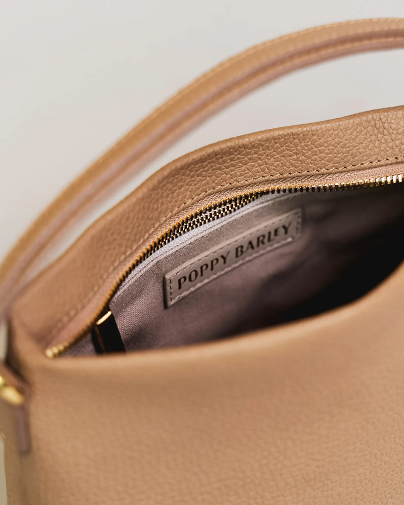 Open interior of the leather mini bag with Poppy Barley branding and gold zipper. The Via Monte Bag Biscotti.