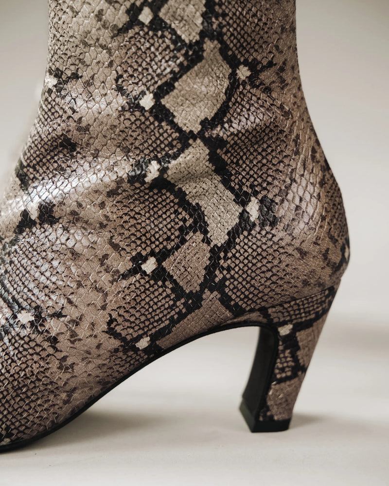 Close-up of taupe snake print ankle boot showing heel detail. The Toujours Boot Taupe Snake. Sizes 5–12, available in wide.
