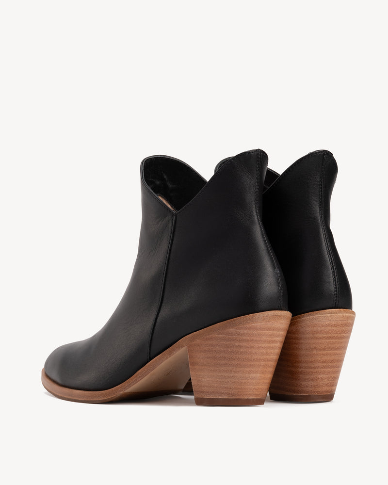 Back view, V-shaped topline, stacked heel. The Two Point Five Ankle Boot Black Water Resistant. Sizes 5–12, wide available.