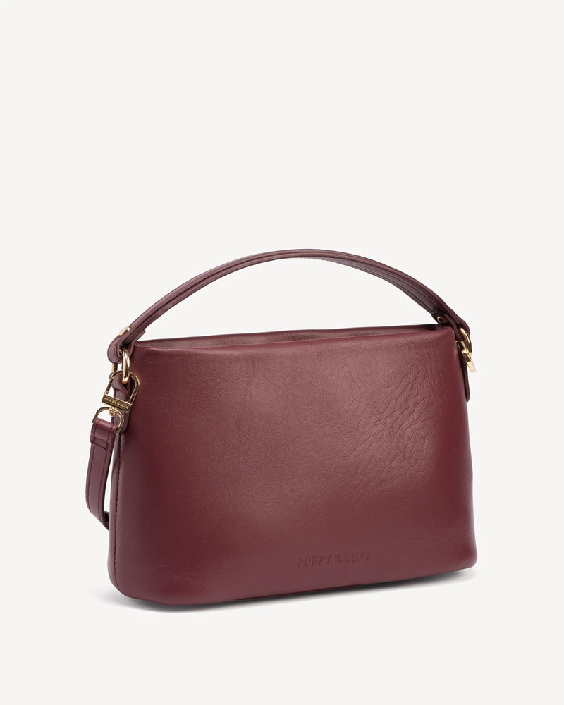 Angled view of rectangular bag showing structured silhouette and handle. The Via Monte Bag Compote.