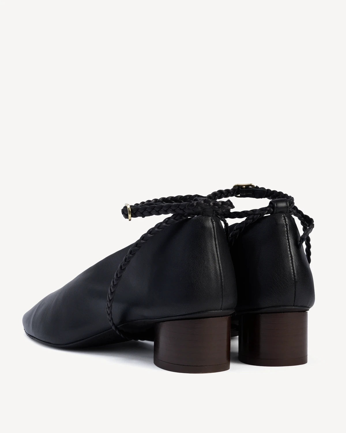 Back view of a pair of pumps with braided ankle straps and block heels. The Alma Anklet Pump Black. Sizes 5–12.
