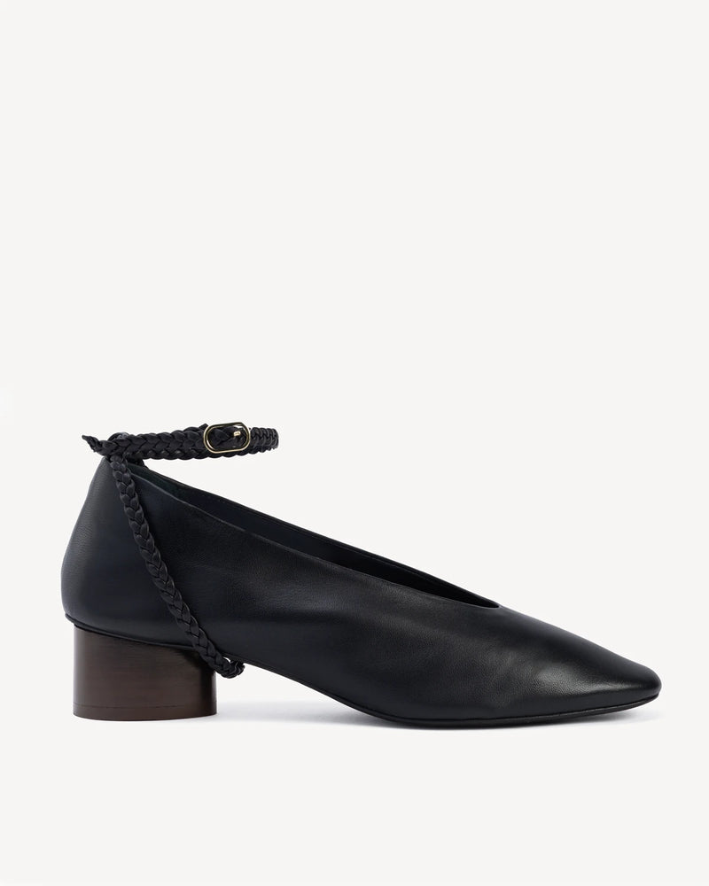 Side view of a leather pump with a braided ankle strap and block heel. The Alma Anklet Pump Black. Sizes 5–12.