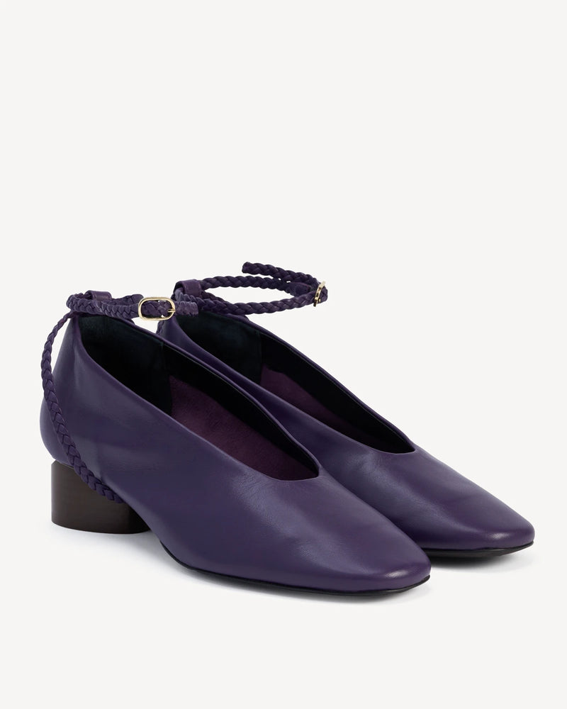 Angled pair of leather pumps with braided ankle straps and block heels. The Alma Anklet Pump Sapphire. Sizes 5–12.