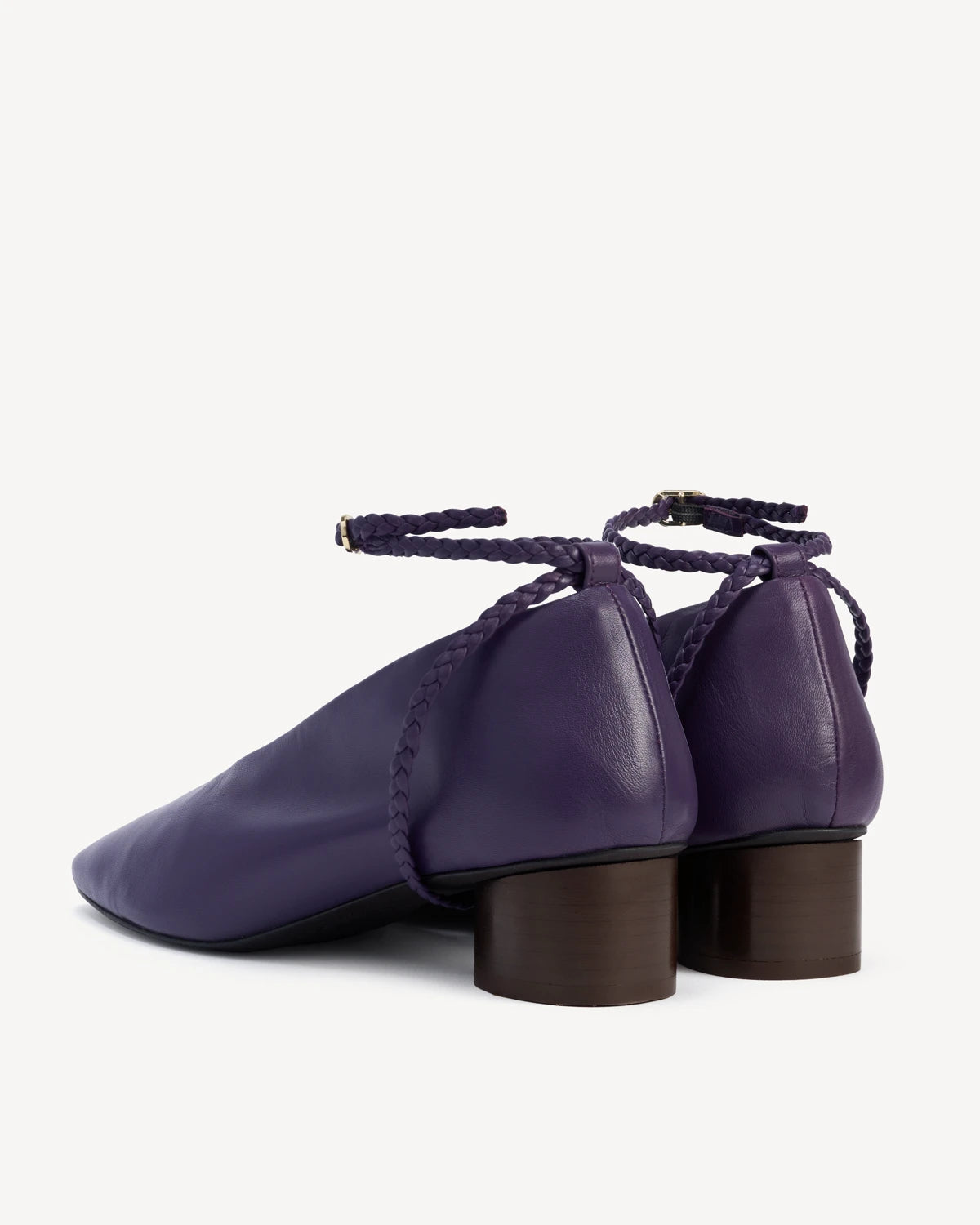 Back view of a pair of pumps with braided ankle straps and block heels. The Alma Anklet Pump Sapphire. Sizes 5–12.