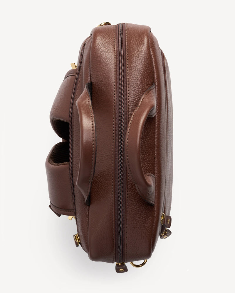 Side profile of the pebbled-leather backpack showing its rounded silhouette. The Backpack French Press.