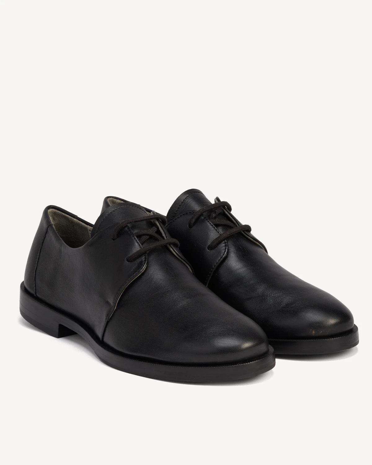 Pair of leather lace-up oxfords shown from a front angle. The Capsule Oxford Black. Sizes 5–12, wide available.