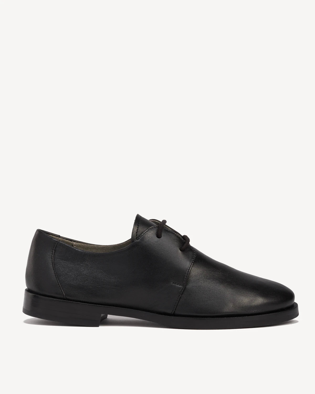 Side view of a leather lace-up oxford with a round toe. The Capsule Oxford Black. Sizes 5–12, wide available.