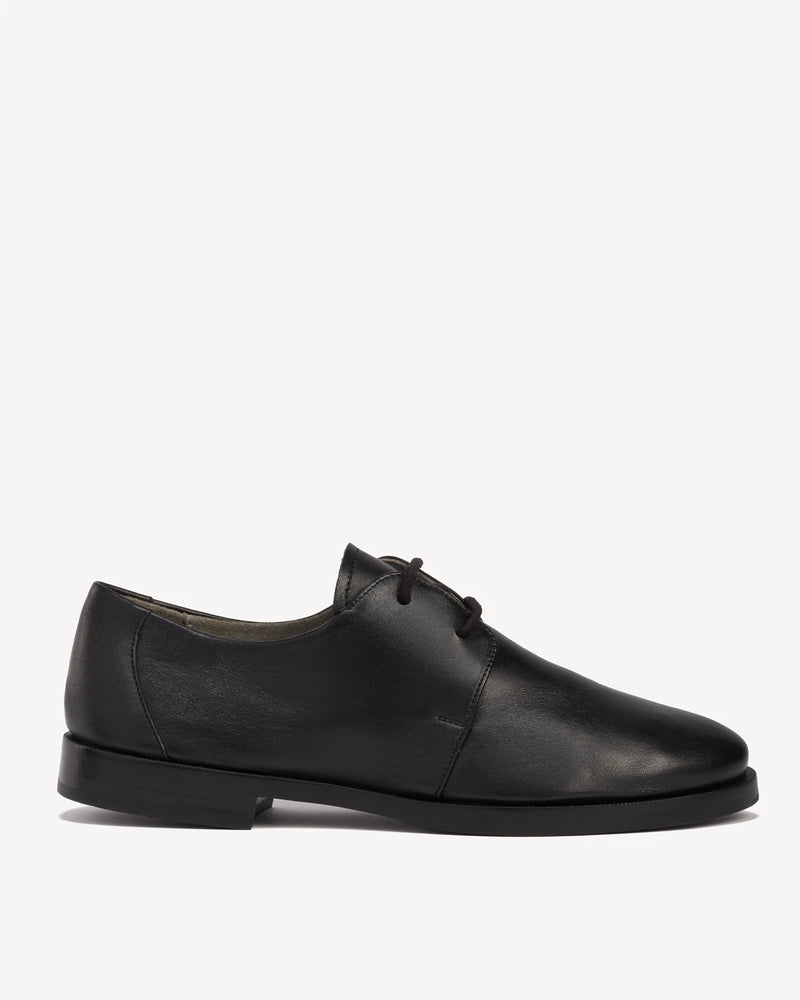 Side view of a leather lace-up oxford with a round toe. The Capsule Oxford Black. Sizes 5–12, wide available.