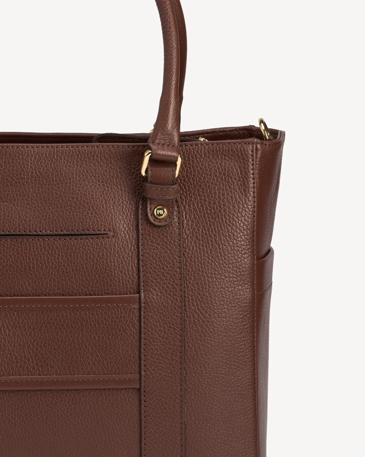 Close-up of exterior slip pockets and zip closure on the leather tote. The Colleague Tote French Press.